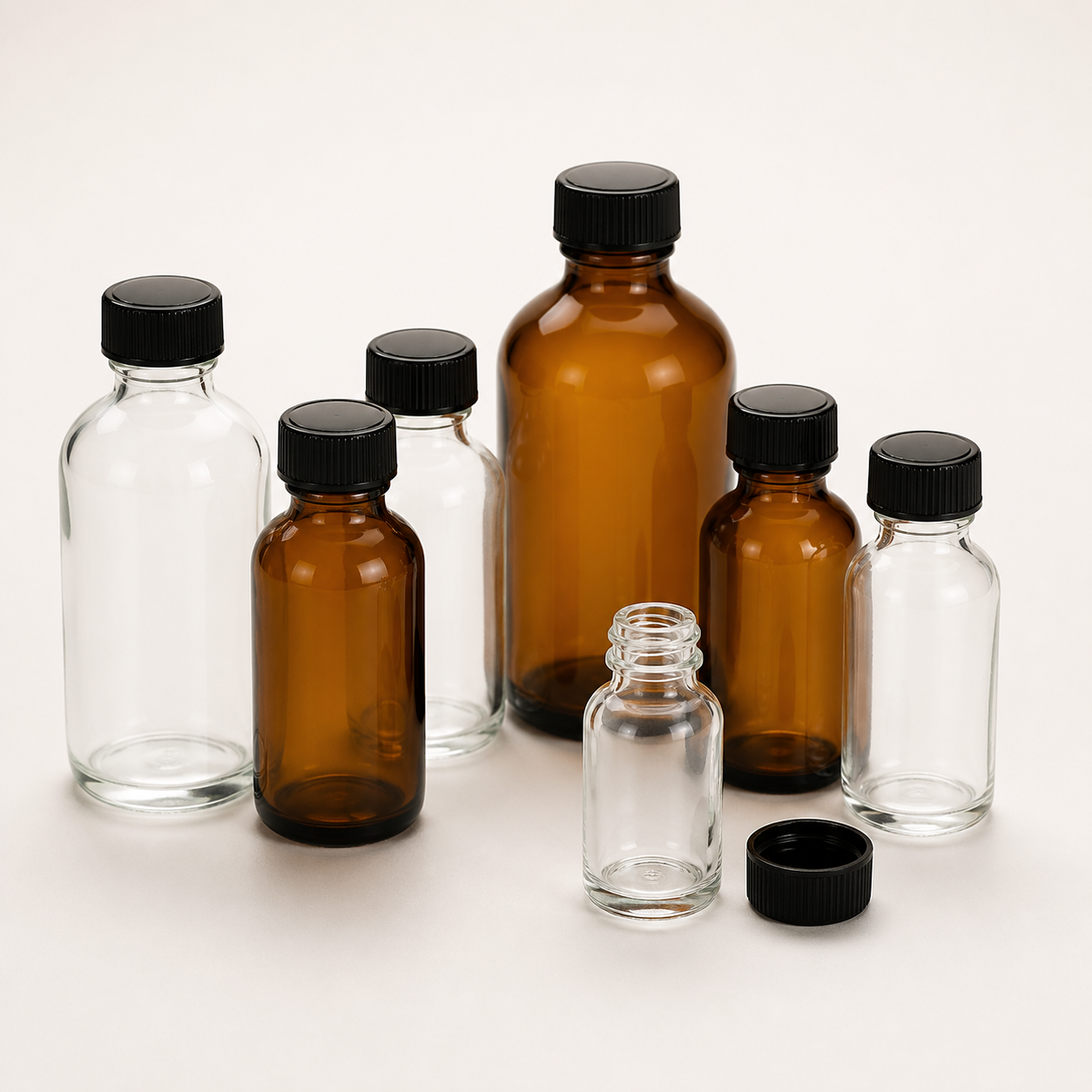 Empty clear and amber round glass bottles with screw caps