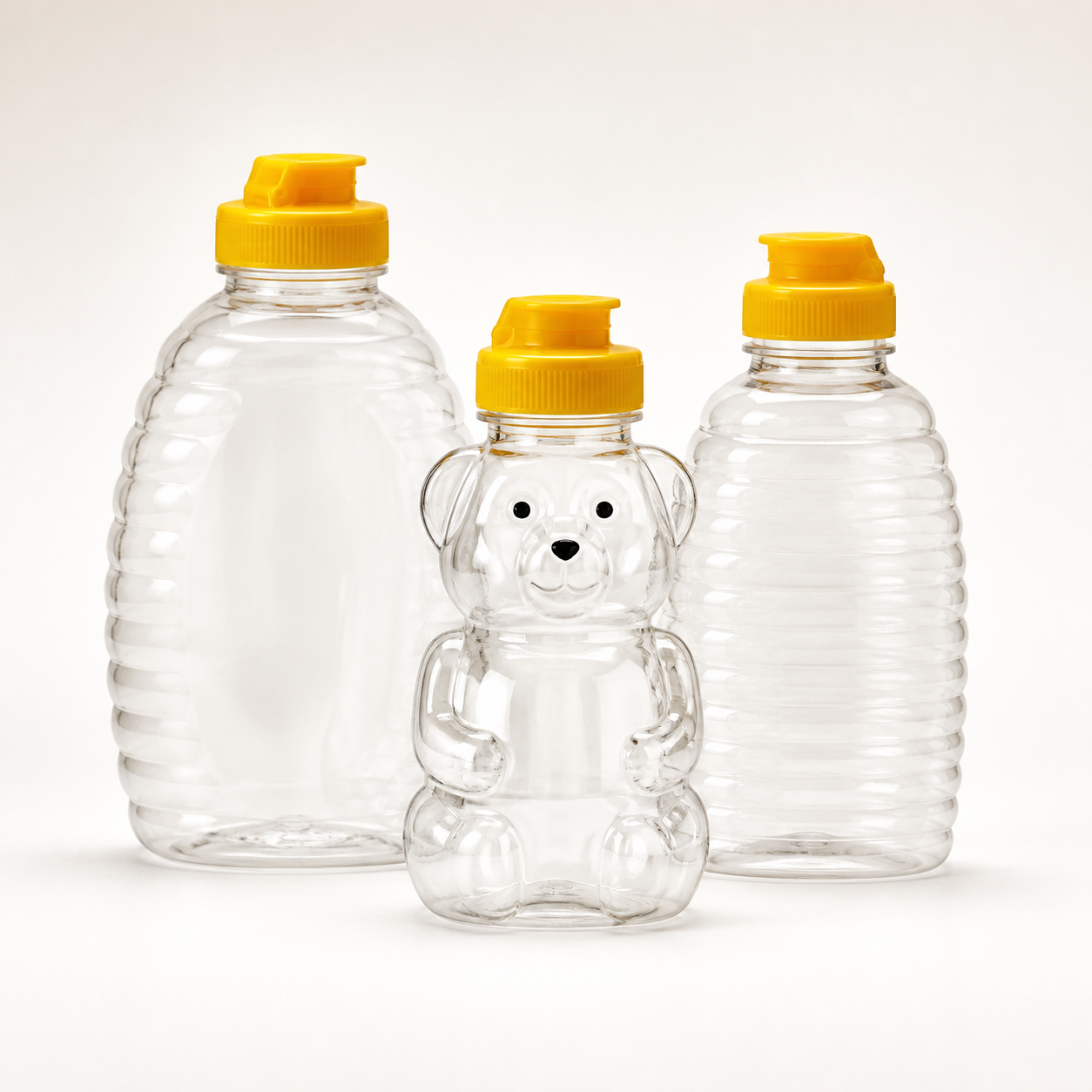 Empty clear PET honey squeeze bottles with yellow dispensing caps