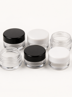Miniature clear cosmetic sample jars with black and white lids
