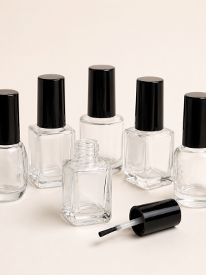 Empty clear glass nail polish bottles with black brush caps