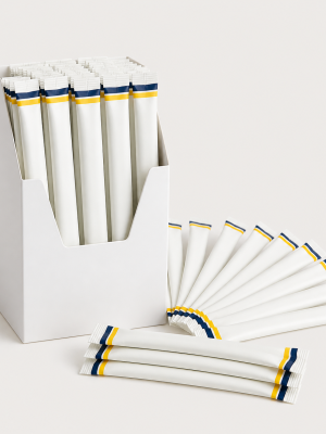 Individually portioned paper sugar sticks in a countertop carton